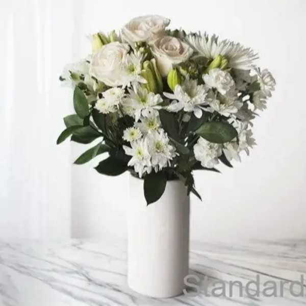 White floral bouquet in a tall white vase