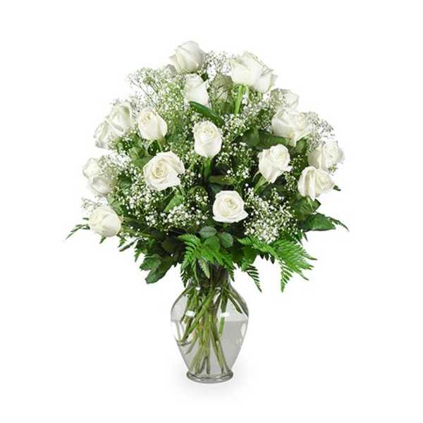 White roses arranged in a clear glass vase with baby's breath