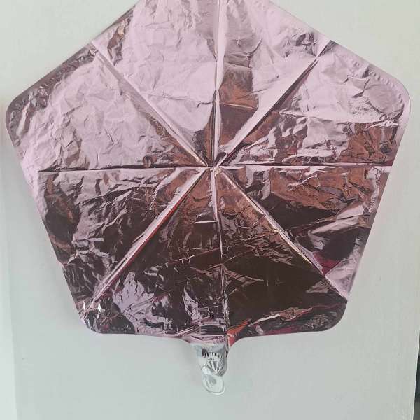 Pink metallic star-shaped foil balloon on a plain background