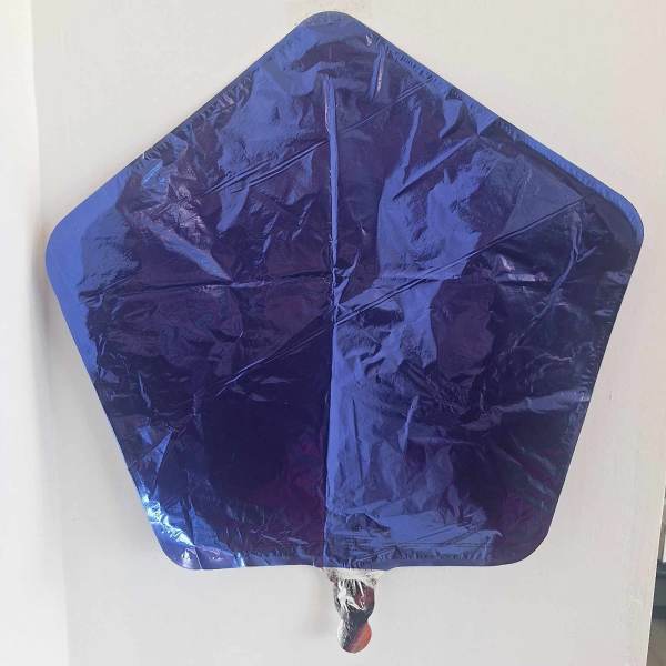 Blue star-shaped foil balloon against a white wall