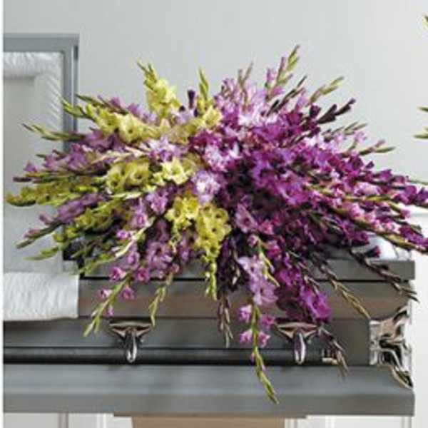 Purple and green floral spray on a casket