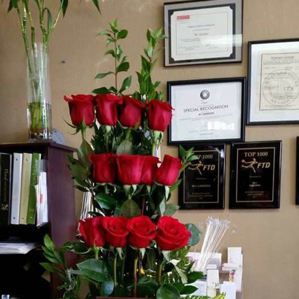 Tall floral arrangement with red roses, white lilies, and pink carnations