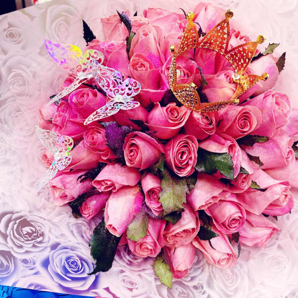 Pink rose bouquet with decorative butterfly picks in patterned wrap