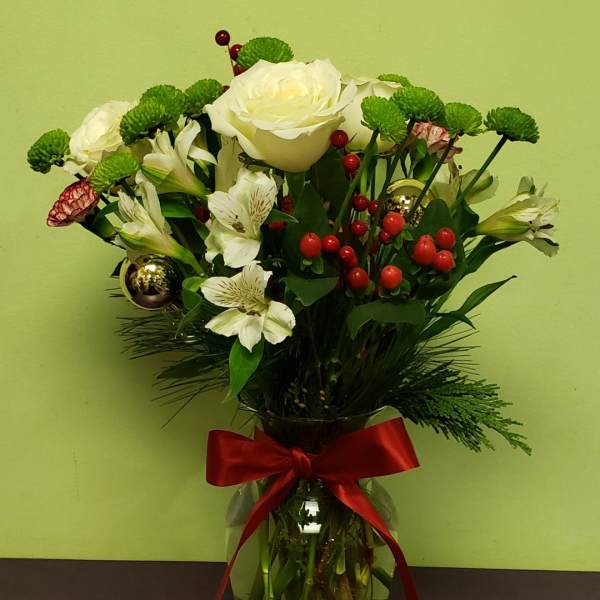 Bouquet of white roses and alstroemeria in a glass vase with a red ribbon