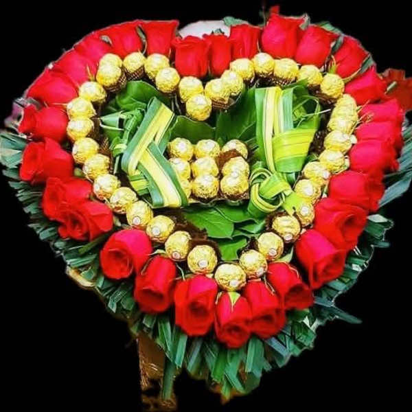 Heart-shaped bouquet of red roses and gold-wrapped chocolates
