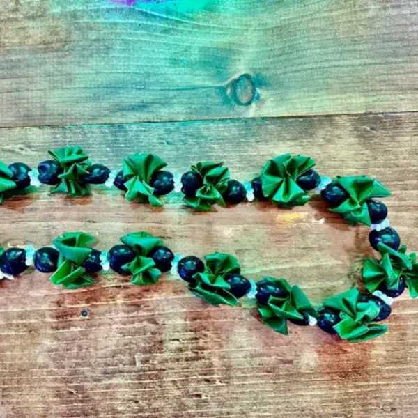 Green and dark blue beaded garland laid on a wooden surface