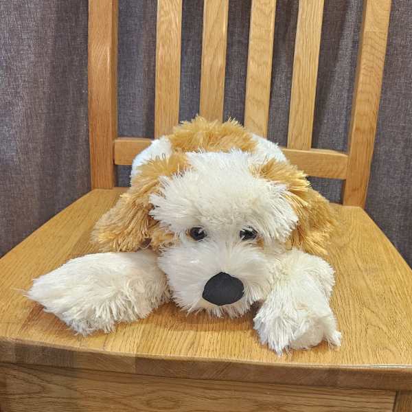 Plush dog toy resting on a wooden chair
