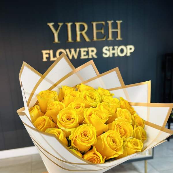 Bouquet of yellow roses wrapped in white and gold paper