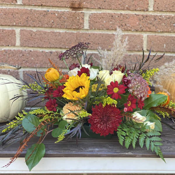 Autumn floral centerpiece with pumpkins on a table