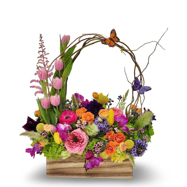 Colorful mixed flower arrangement in a wooden box with butterfly accents