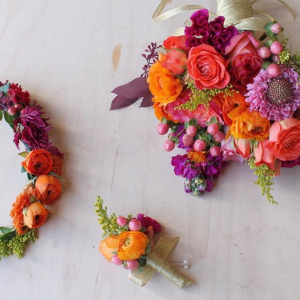 Colorful floral bouquet, wreath, and boutonniere on a light background