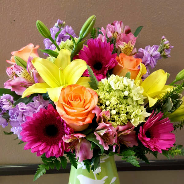 Colorful bouquet with lilies, roses, gerbera daisies, and alstroemeria in a green vase