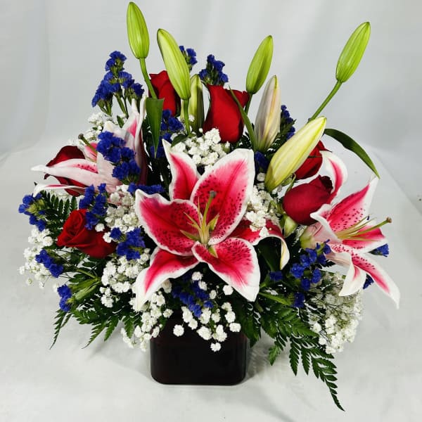 Bouquet of red roses and pink lilies in a black vase