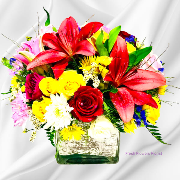 Colorful mixed bouquet in a square glass vase