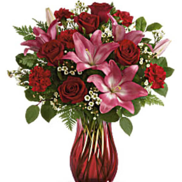 Red roses and pink lilies in a red glass vase