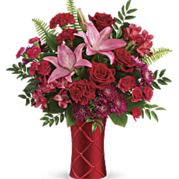 Red and pink mixed bouquet in a red vase