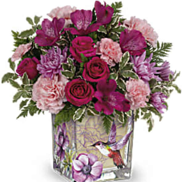 Pink and purple bouquet in a square glass vase with bird artwork