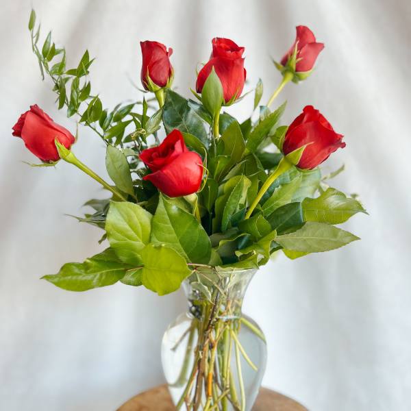 Red roses arranged in a clear glass vase