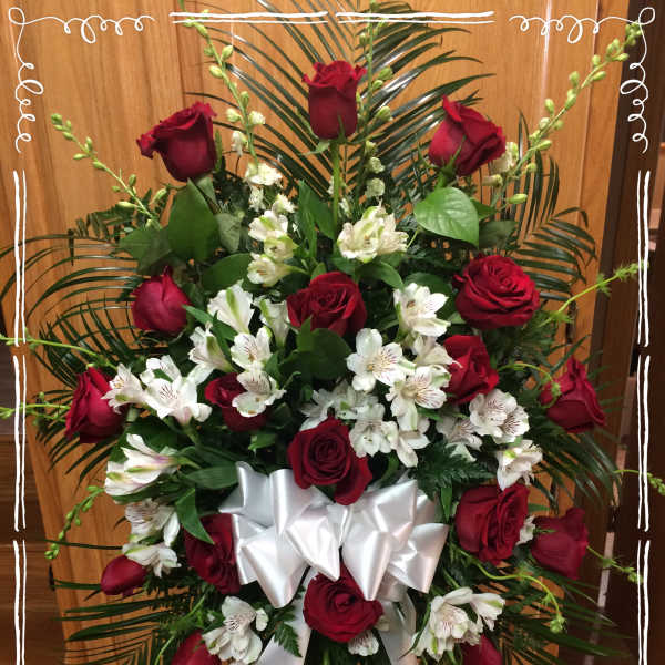 Standing spray of red roses and white alstroemeria with a white ribbon bow
