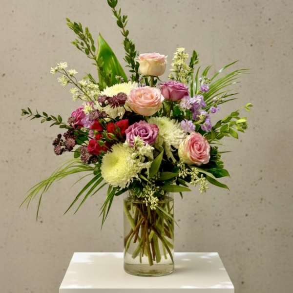 Mixed bouquet of pink and white flowers in a clear glass vase