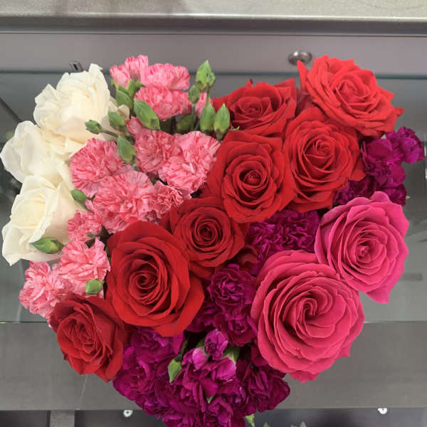 Heart-shaped bouquet of red, pink, and white roses with carnations