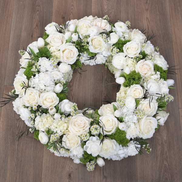 White and cream rose wreath with green accents arranged in a circular ring
