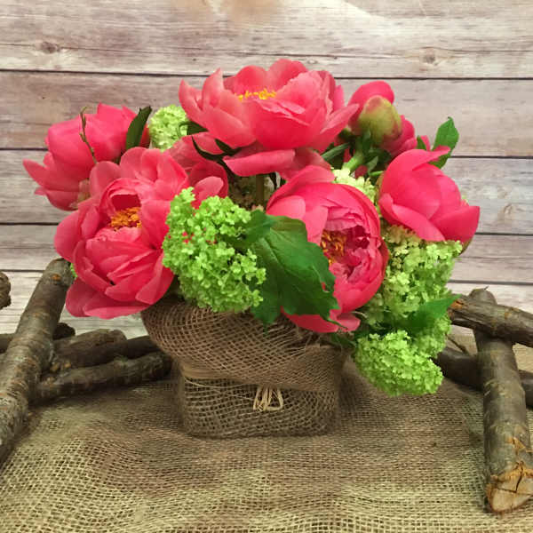 Pink peony bouquet in a burlap-wrapped container