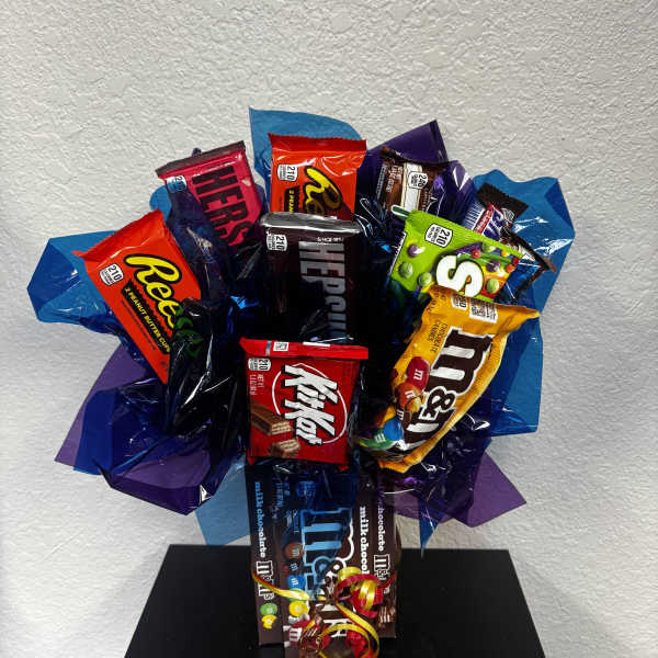 Bouquet made of assorted candy bars and chocolates wrapped in blue and purple paper.