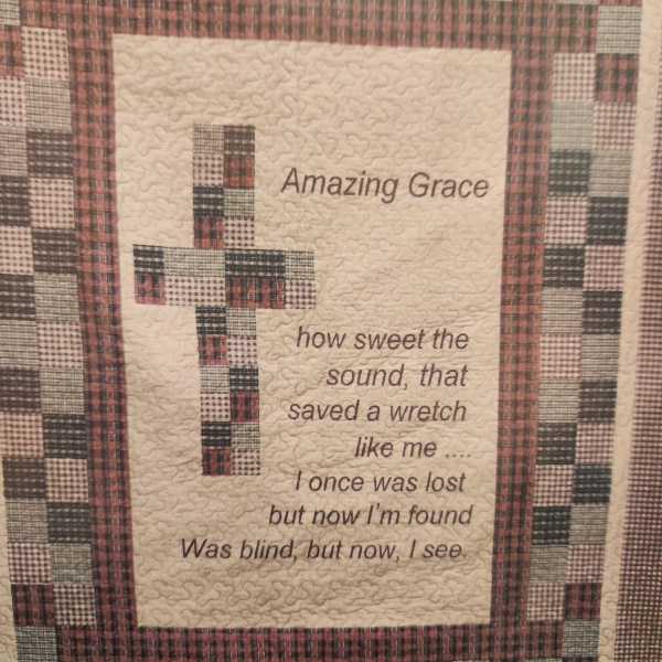 Quilted wall hanging with a cross and the words "Amazing Grace"