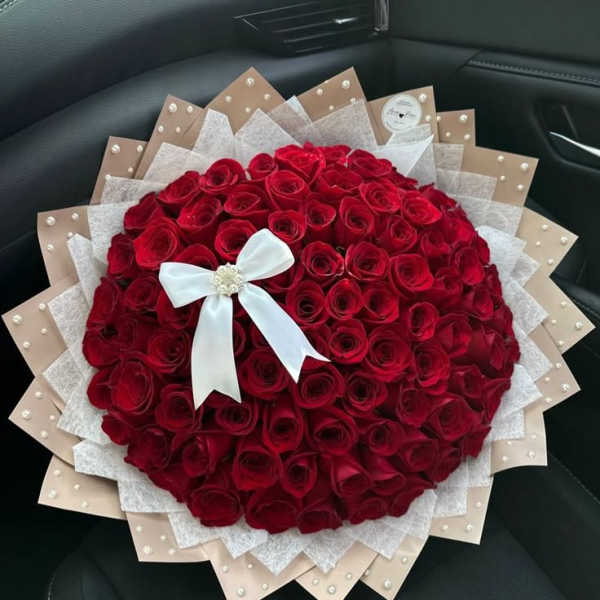 Large bouquet of red roses with a white ribbon bow