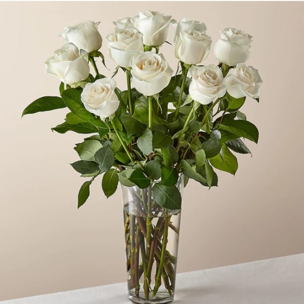 White roses arranged in a clear glass vase