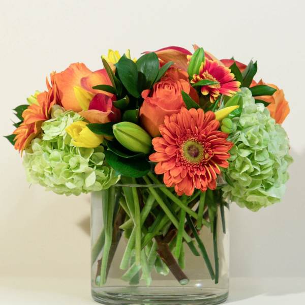 Orange and yellow mixed bouquet in a clear glass vase