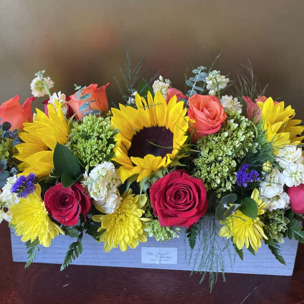 Bright mixed flower arrangement in a white rectangular box