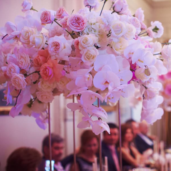Pink and white floral centerpiece with roses and orchids