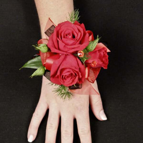 Red rose wrist corsage with ribbon on a wrist