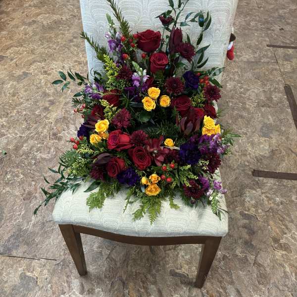 Mixed bouquet of red, yellow, and purple flowers on a chair