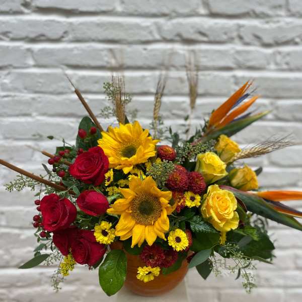 Bouquet of red and yellow flowers in a round vase
