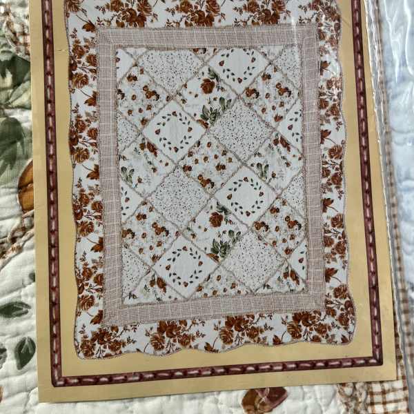 Packaged quilt with a floral patchwork pattern in cream and brown