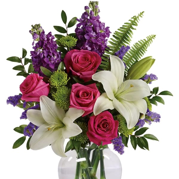 Pink roses and white lilies in a clear glass vase