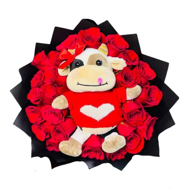 Round arrangement of red roses with a plush cow toy in a red heart sweater