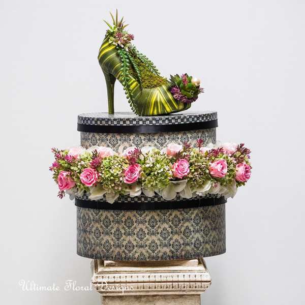 High-heel shoe sculpture topped with flowers and a pink rose garland