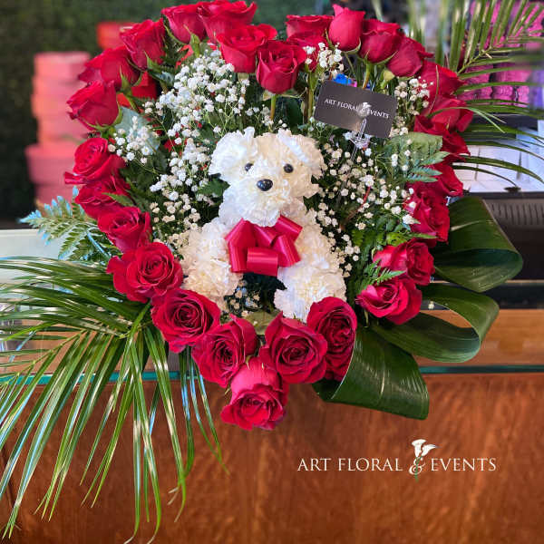 Heart-shaped rose arrangement with a white teddy bear in the center