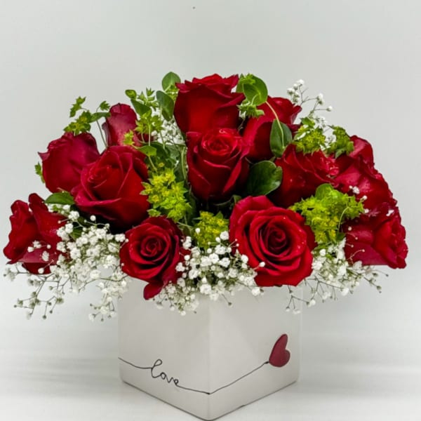 Red roses in a white square box with baby’s breath