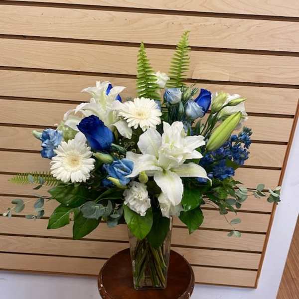 Blue and white floral arrangement in a clear glass vase