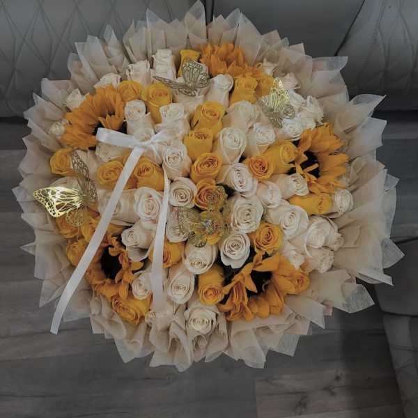 Bouquet of white and yellow roses with sunflowers and butterfly accents