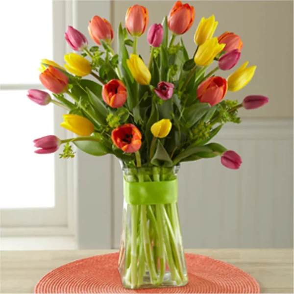 Bouquet of multicolored tulips in a clear glass vase