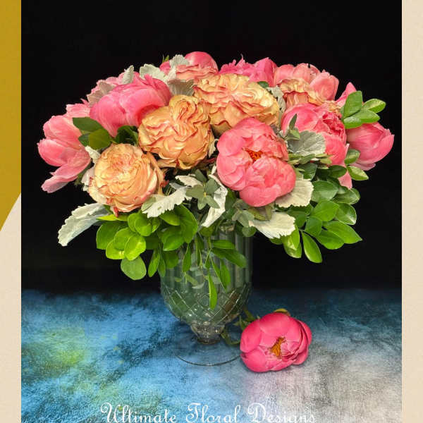 Pink and peach peonies arranged in a glass vase