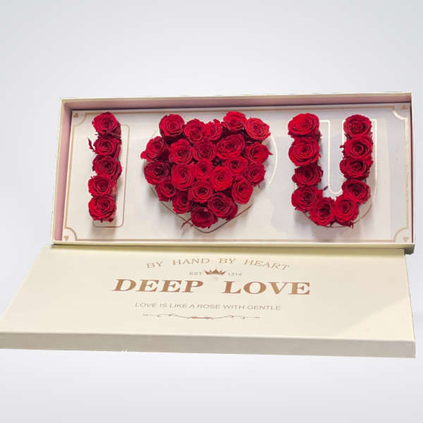 Red roses arranged to spell I love you in a gift box