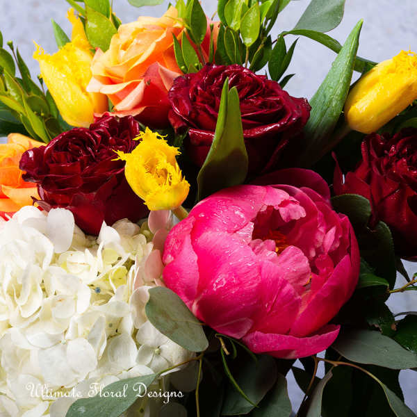 Bouquet of red and pink roses with a pink peony and white hydrangea