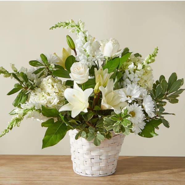 White floral arrangement in a white woven basket